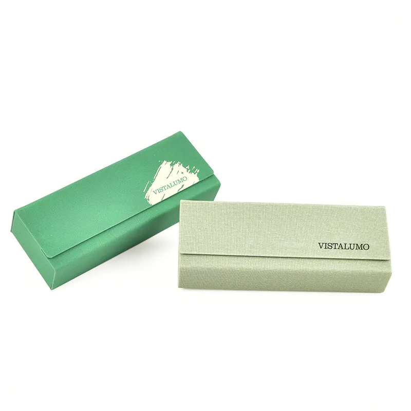 Two VISTALUMO magnetic eyeglass cases shown closed — emerald green with painted brand mark and sage linen-textured finish