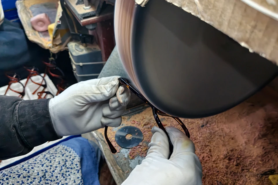hand polishing aceate glasses frames by skillful worker.