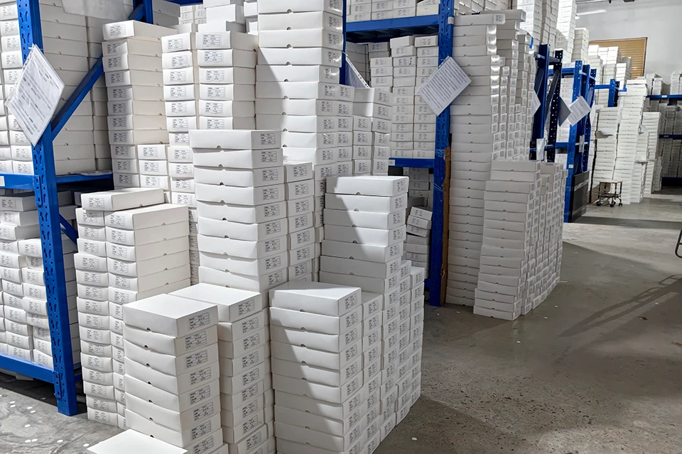 a warehouse store thousand of pair of acetate sunglasses in white boxes.