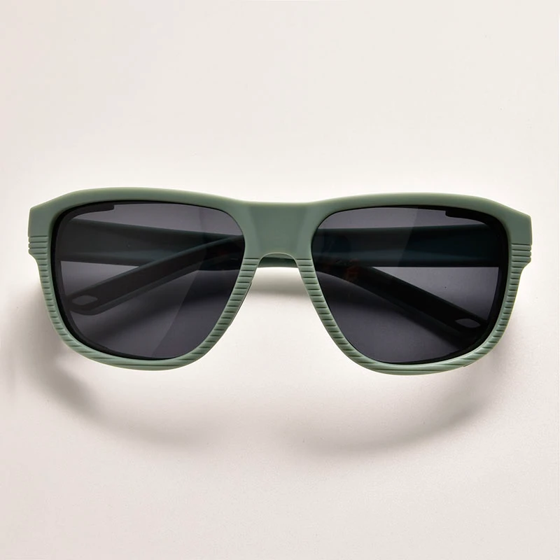 Front view of matte sage green side protection sunglasses. Features a ribbed textured frame and dark lenses for anti-glare outdoor safety. Available for bulk wholesale.