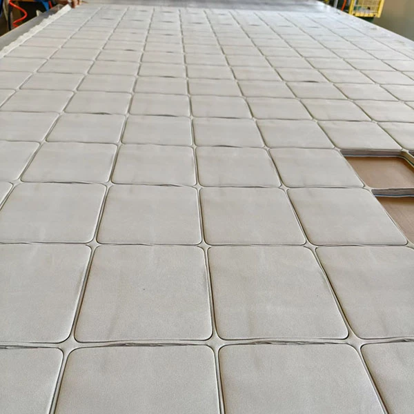 Close-up of the manufacturing process for microfiber cleaning cloths, showing precision edge cutting.